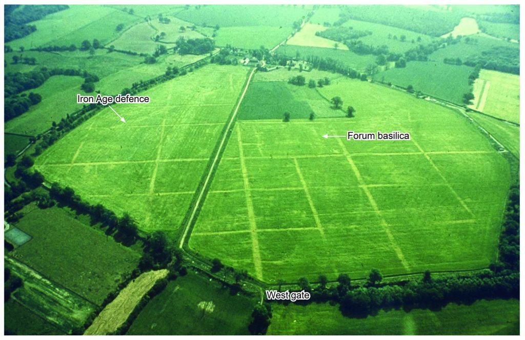 Colour oblique aerial photographs of Silchester Roman Town showing the roughly hexagonal area surrounded by town walls within which the grid road network shows as pale crop marks.