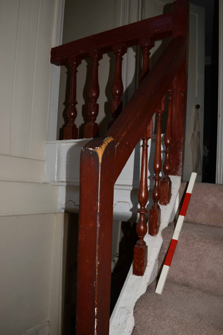 Colour photo of a narrow staircase with a timber balustrade.