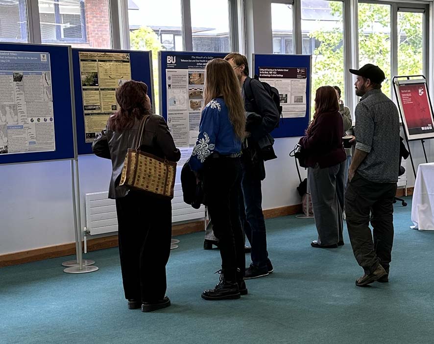 People viewing conference posters and discussing the details.